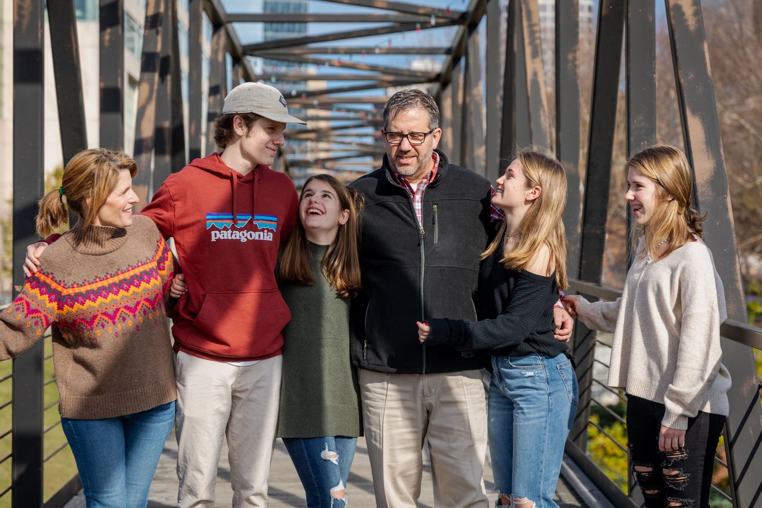 Wide group shots on a bridge showing multiple people in casual winter attire.