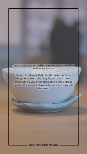 White kimchi served in artistic bowl combining ancient pottery with modern porcelain design elements.