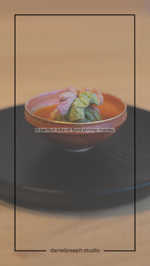 Colorful shrimp mandiri dish presented in terra cotta bowl on black plate.