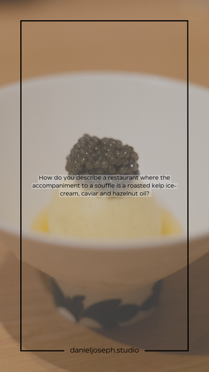 Black caviar served atop yellow sauce in white bowl with decorative bat pattern.