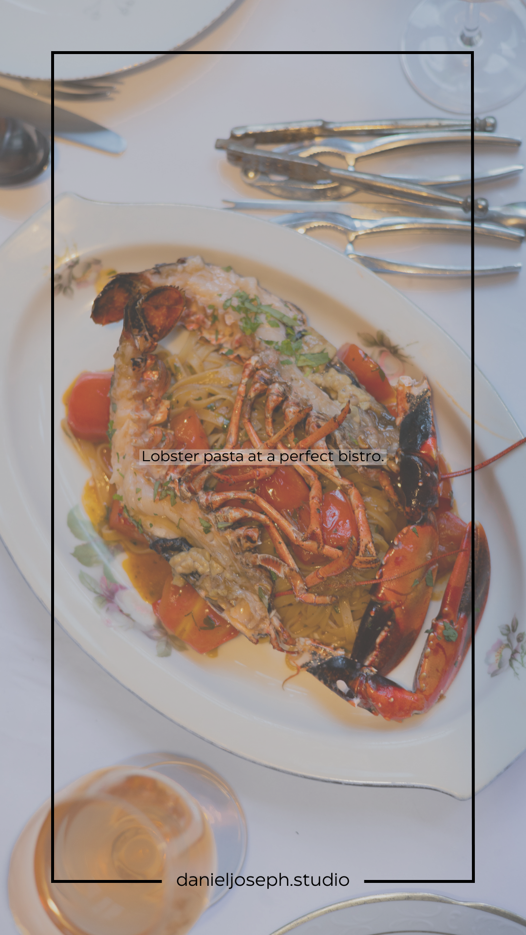 Luxurious lobster pasta dish served on white plate with sauce and garnish in an elegant restaurant setting.
