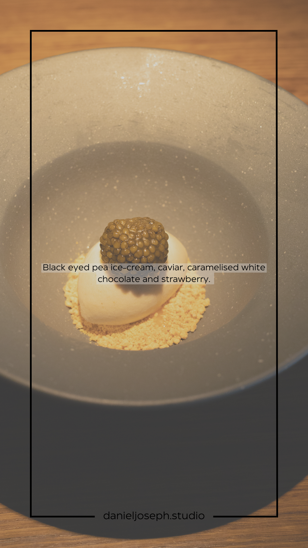 Black-eyed pea ice cream with caviar served on a bed of crumbs in a white ceramic bowl.