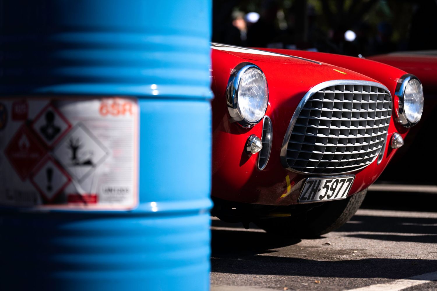 Artistic detail shots of vintage race car grilles and headlights against blue and red backgrounds.