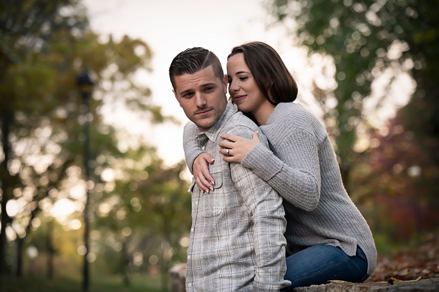 Couple embracing outdoors in casual fall attire.