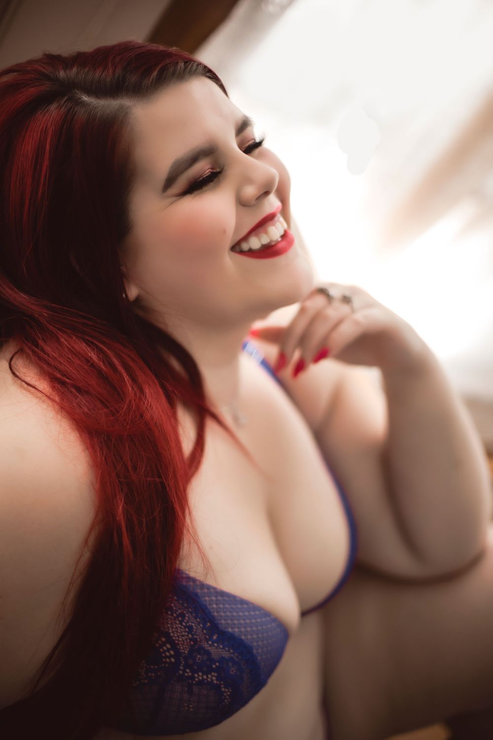 Intimate portrait with soft lighting showcasing lace lingerie and natural expression.