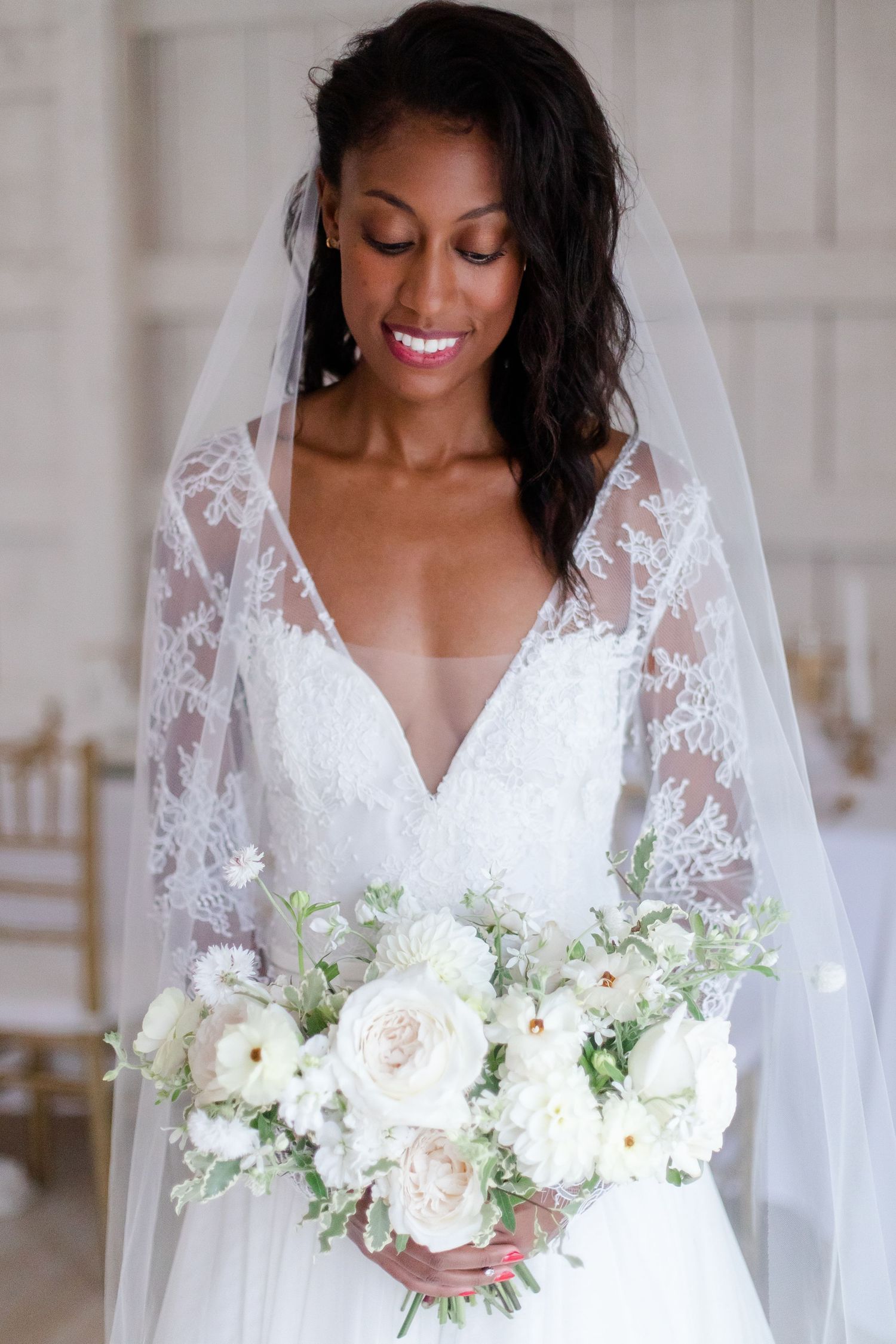 A beautiful bridal portrait showcasing an elegant lace wedding gown and white bouquet.