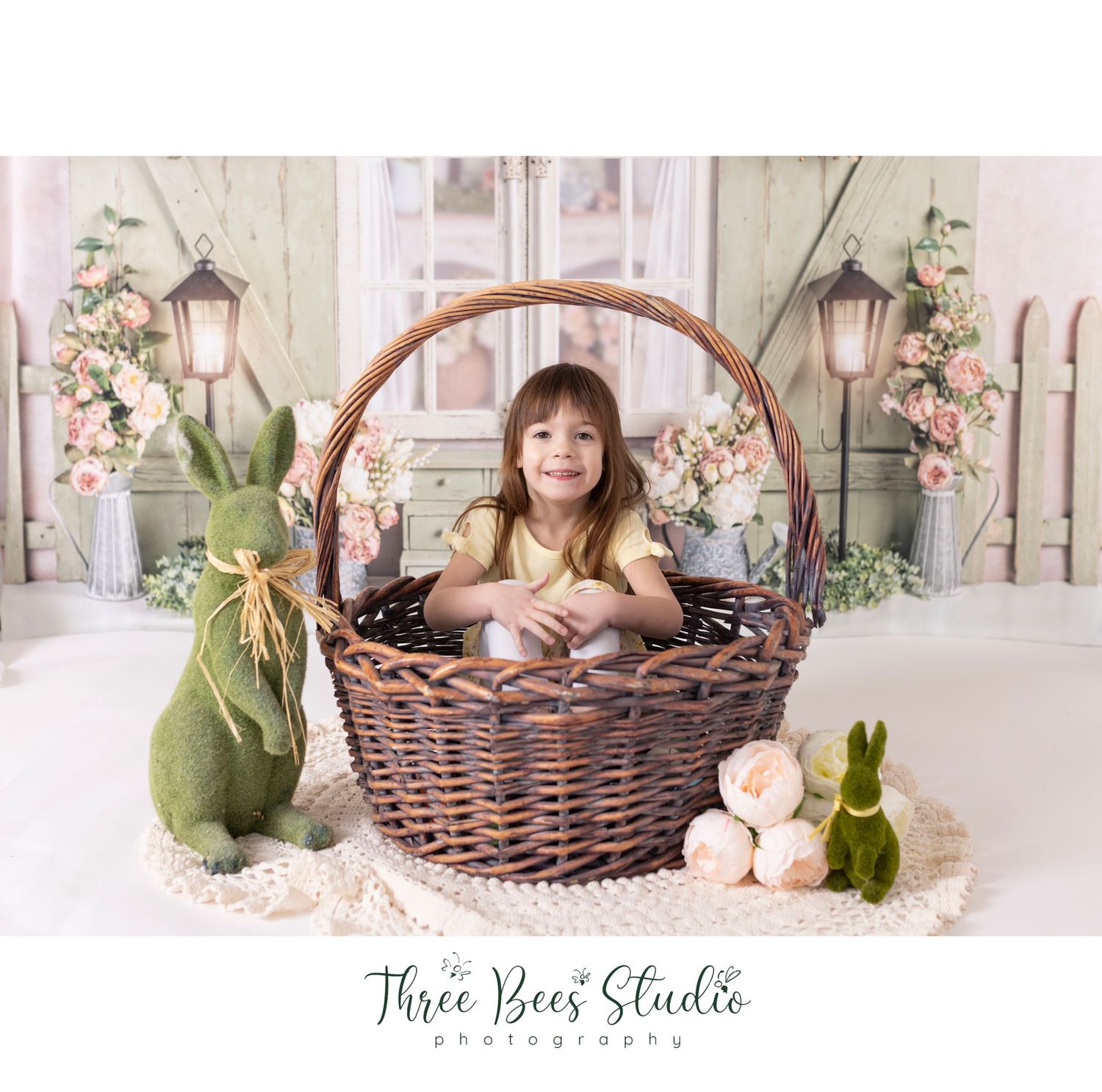 Easter themed photo with large wicker basket and decorative bunnies.