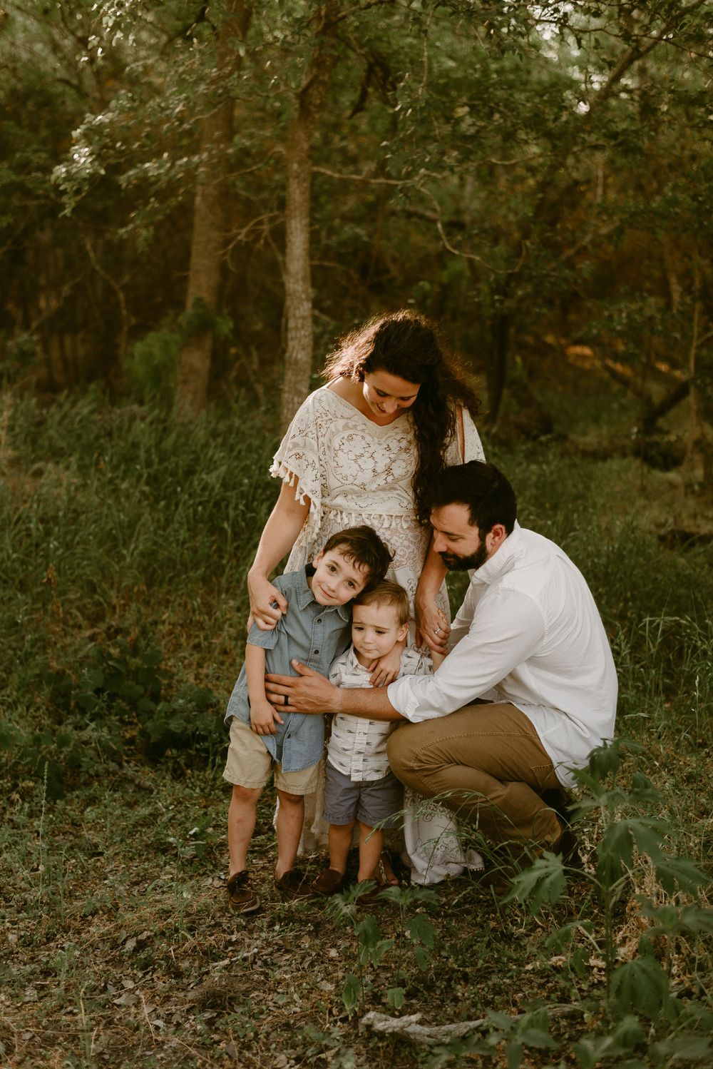 Family sharing an intimate moment together in a wooded setting.