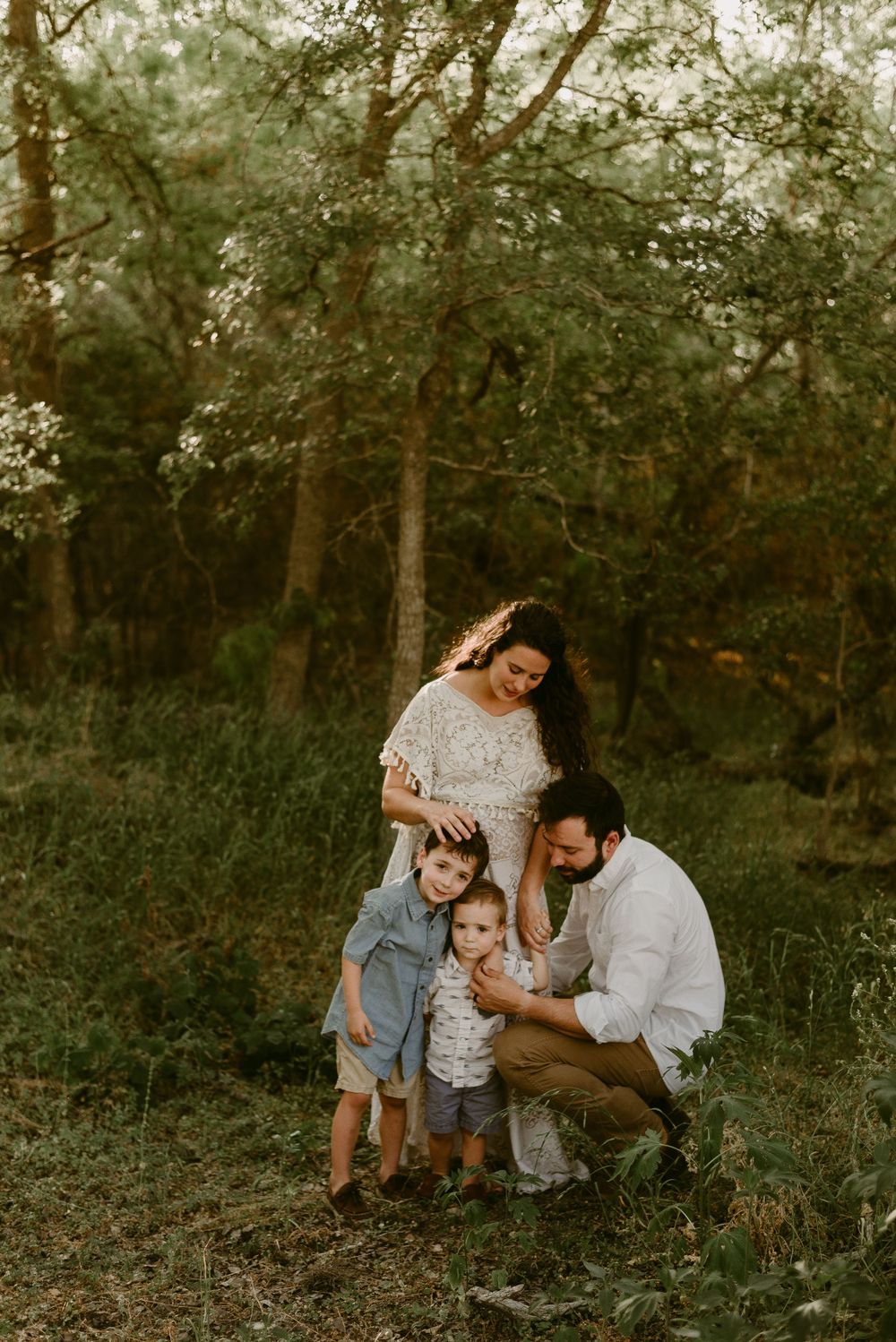 Family portrait in a wooded area during golden hour.