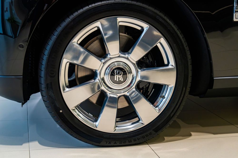Chrome finished alloy wheel of a Rolls-Royce with distinctive RR center cap.