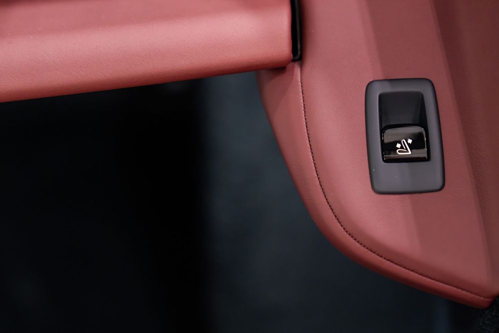 Close-up of a burgundy leather interior panel with a black power button control.