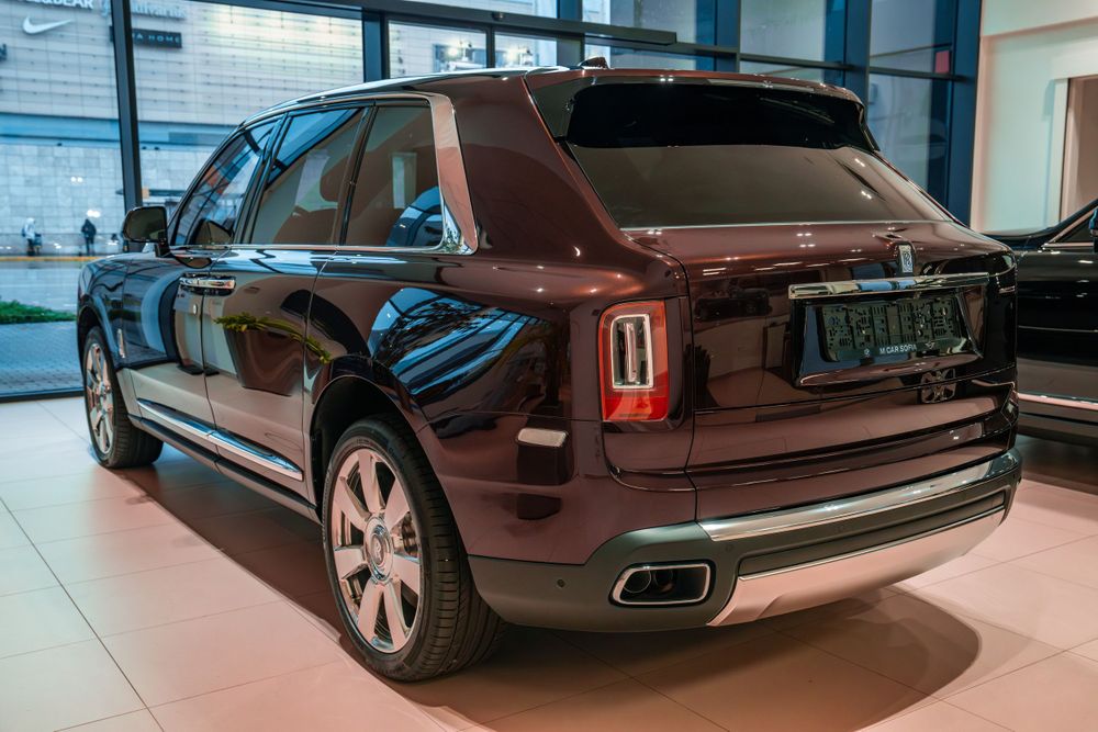 Rear view of a maroon Rolls-Royce Cullinan showing its distinctive taillight design.