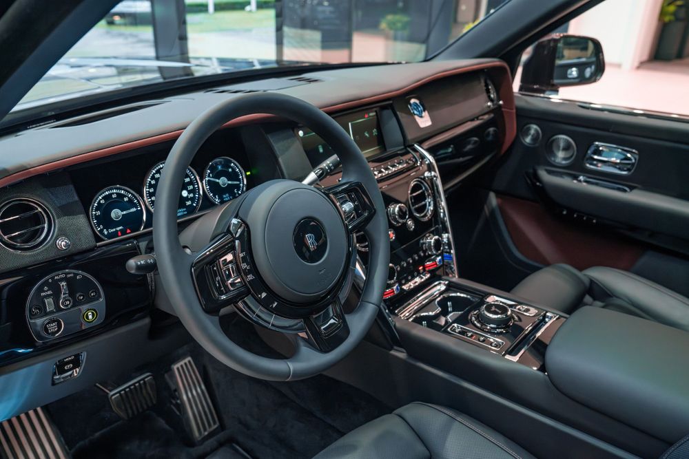 Luxurious interior dashboard of a Rolls-Royce featuring leather trim and modern controls.