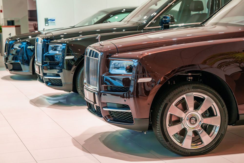 Close-up view of multiple Rolls-Royce Cullinan SUVs lined up in a dealership.