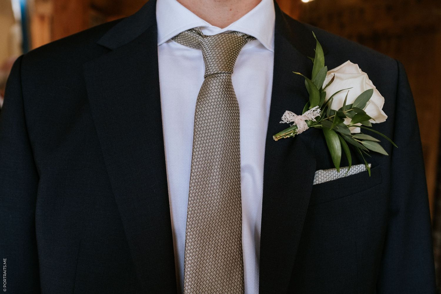 A groom's suit and boutonniere on his wedding day.