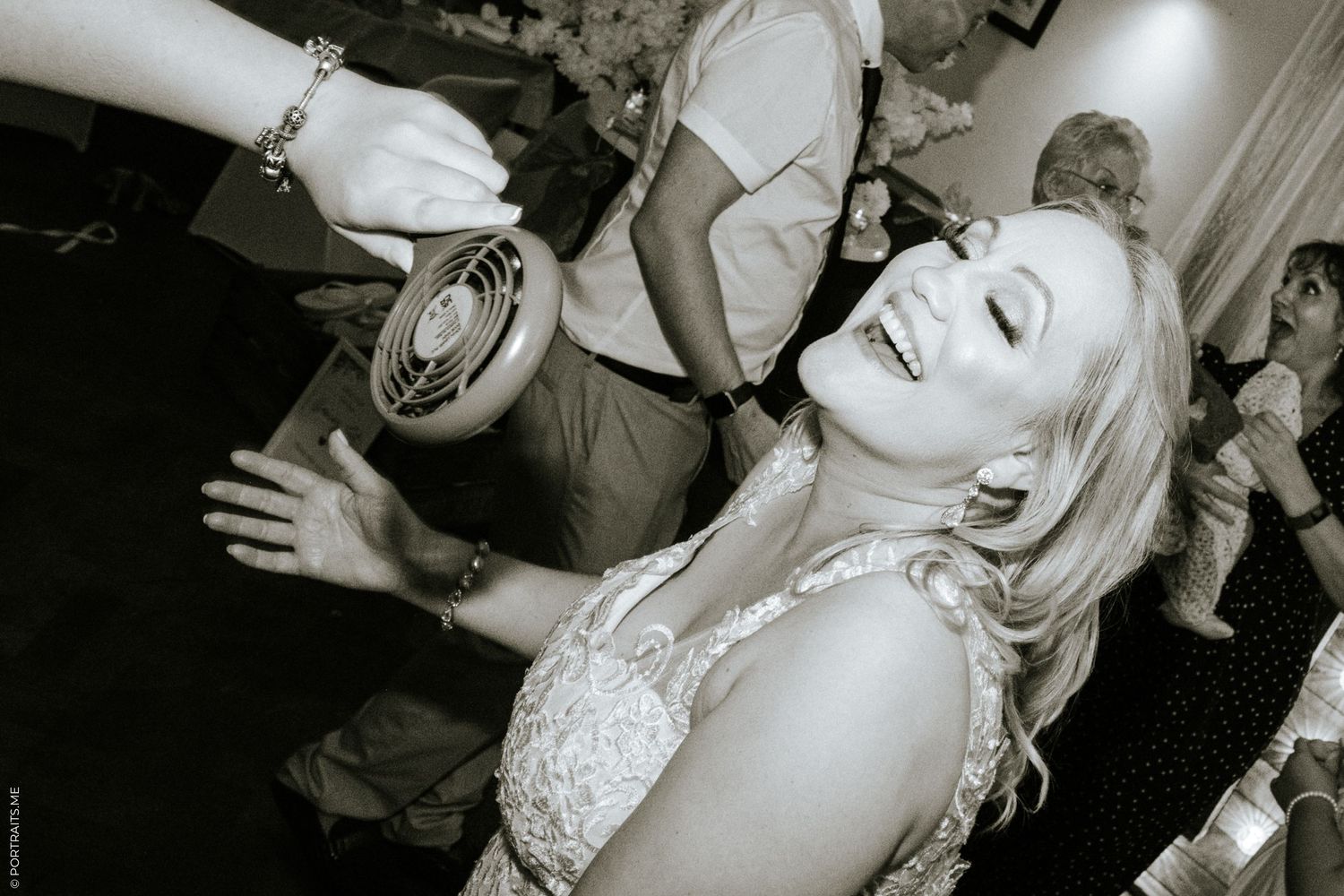 A man fans a woman dancing at a wedding in London.