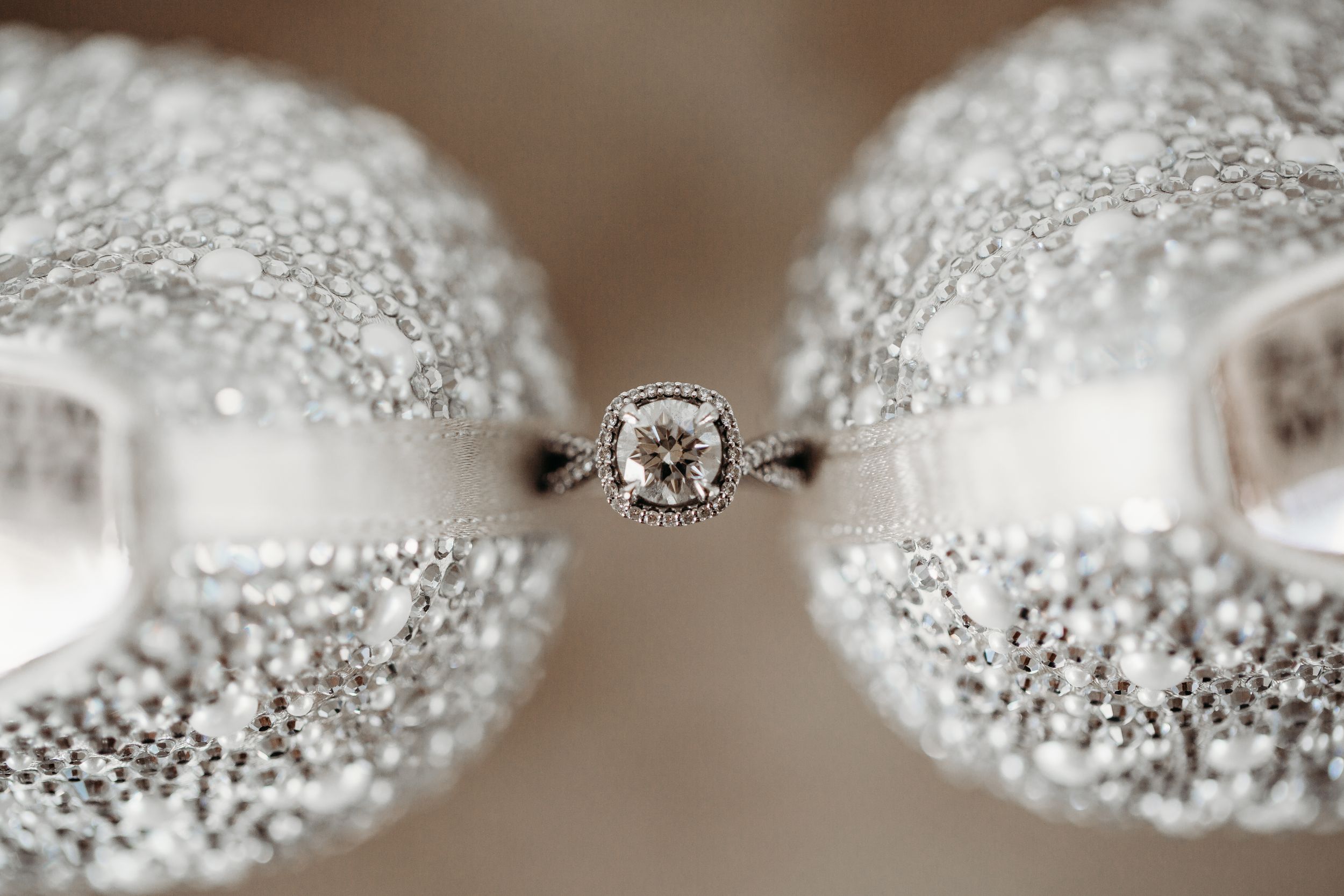 A diamond engagement ring between the heels of the bride's shoes in Houston, TX.