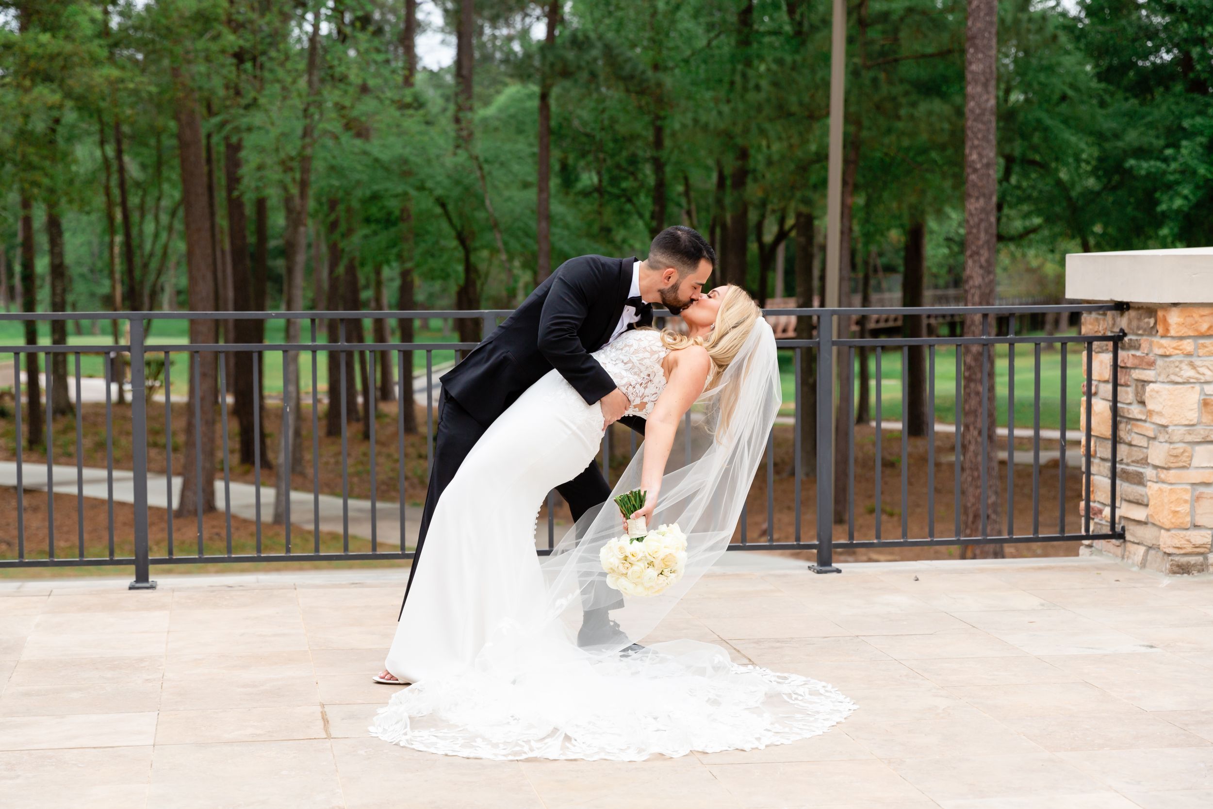Newly married couple does a dip on the balcony at The Woodlands Country Club in The Woodlands, TX.