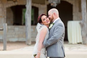Groom kisses bride on the cheek while she giggles after their wedding in Houston, TX.