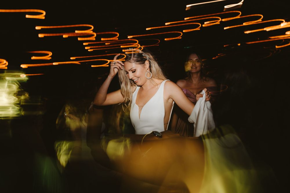 Wedding reception dance floor with orange light trails and atmospheric lighting effects.