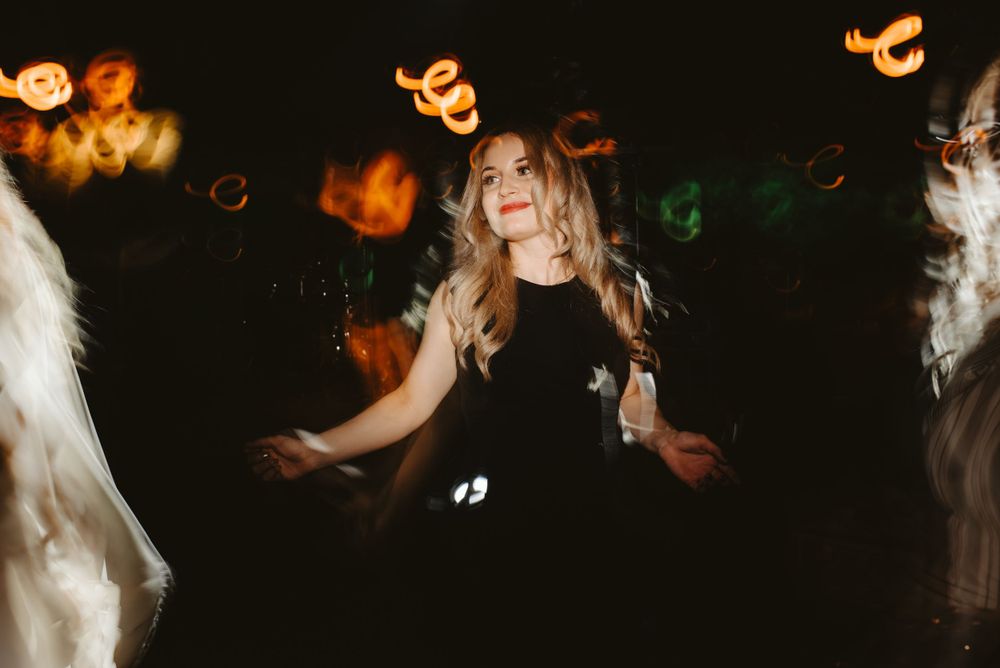 Festive dance floor scene with colorful bokeh lights and motion blur effects.