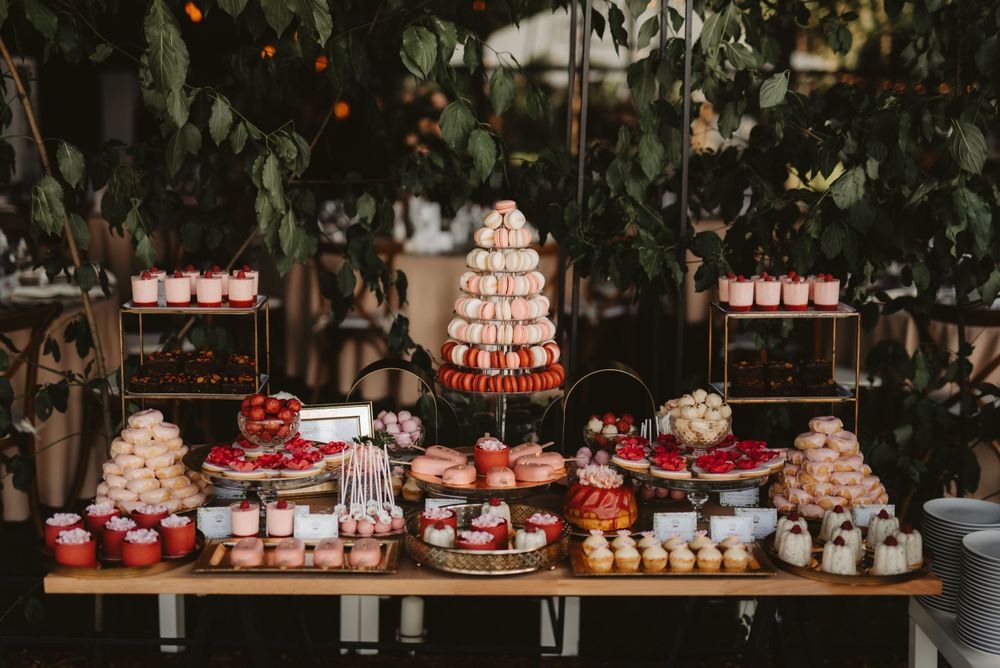 Luxurious dessert table with multi-tiered wedding cake and various sweet treats.