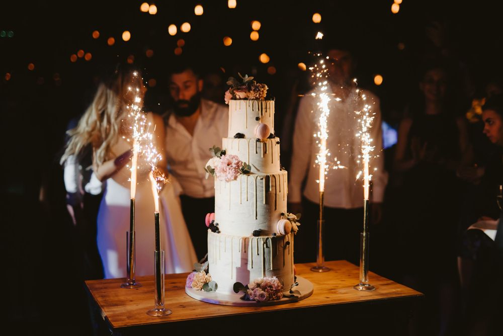 Elegant wedding cake display with sparklers creating a magical atmosphere.