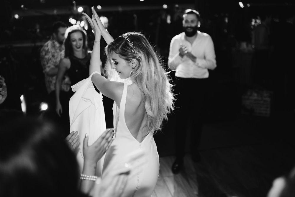 A bride dances with her hair flowing at a dimly lit reception.