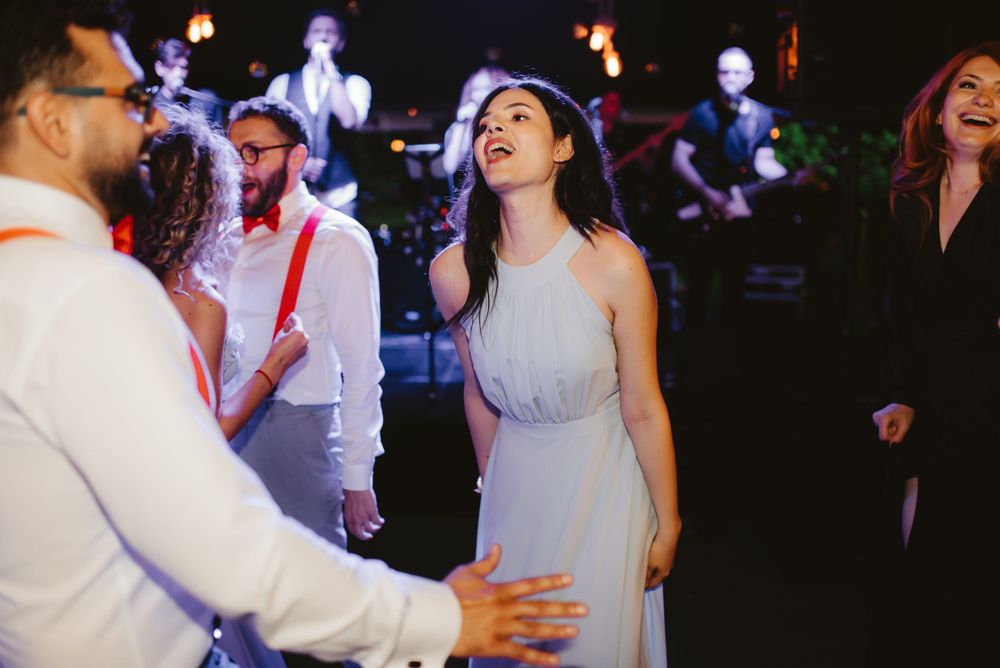 Wedding guests dancing and laughing together on a lively dance floor.