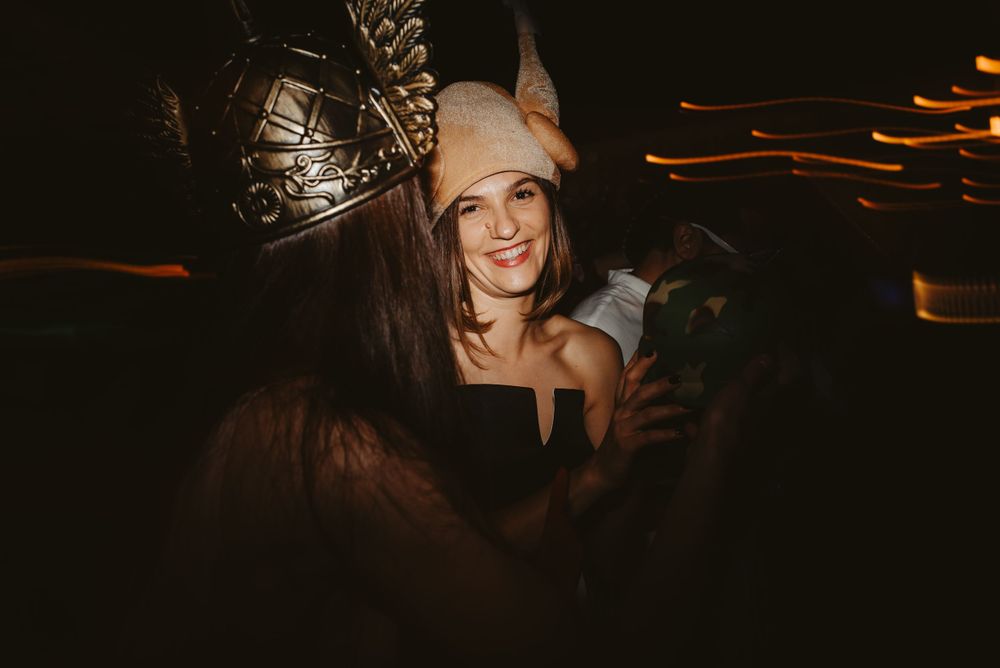 Party guests celebrate in festive attire with warm lighting.