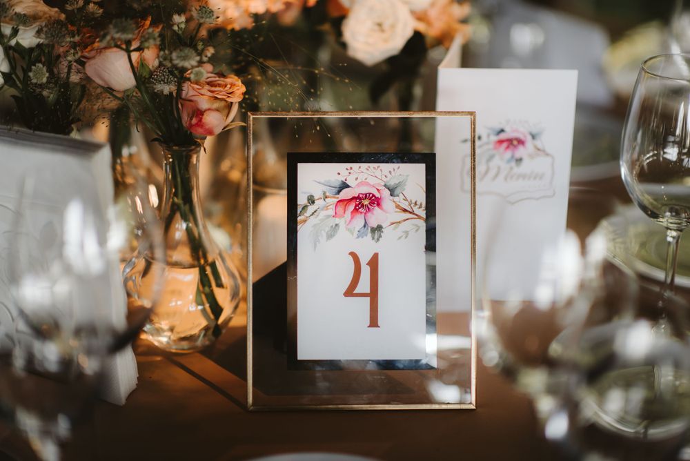 Table number four displayed in gold frame with floral design at wedding reception.
