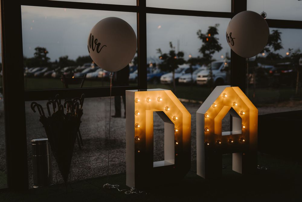 Illuminated marquee letters and balloons create romantic wedding atmosphere.