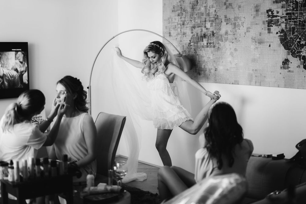 Black and white photo of wedding preparation celebration with people gathered around.