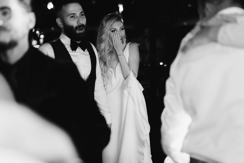 A couple shares an emotional moment on the dance floor at an elegant black-tie event.