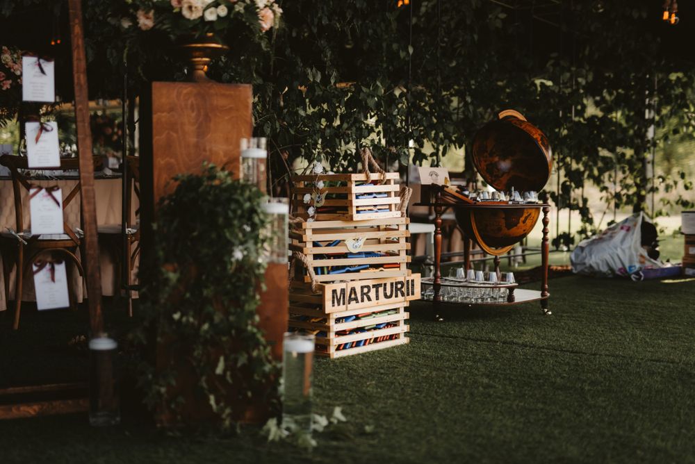 Outdoor wedding venue setup with wooden decor elements and ambient lighting.