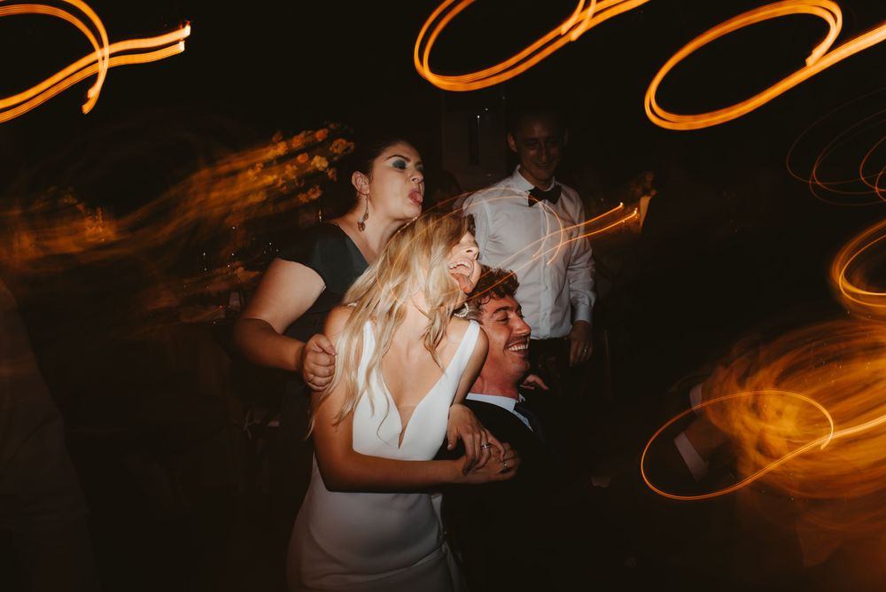Dance party scene with dynamic orange light trails and motion blur effects.