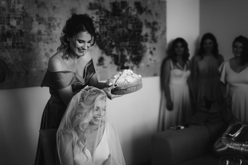 Black and white candid photo of bridal party during wedding day preparations.