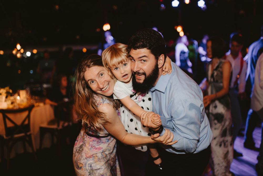Party guests share a joyful embrace on the dance floor.
