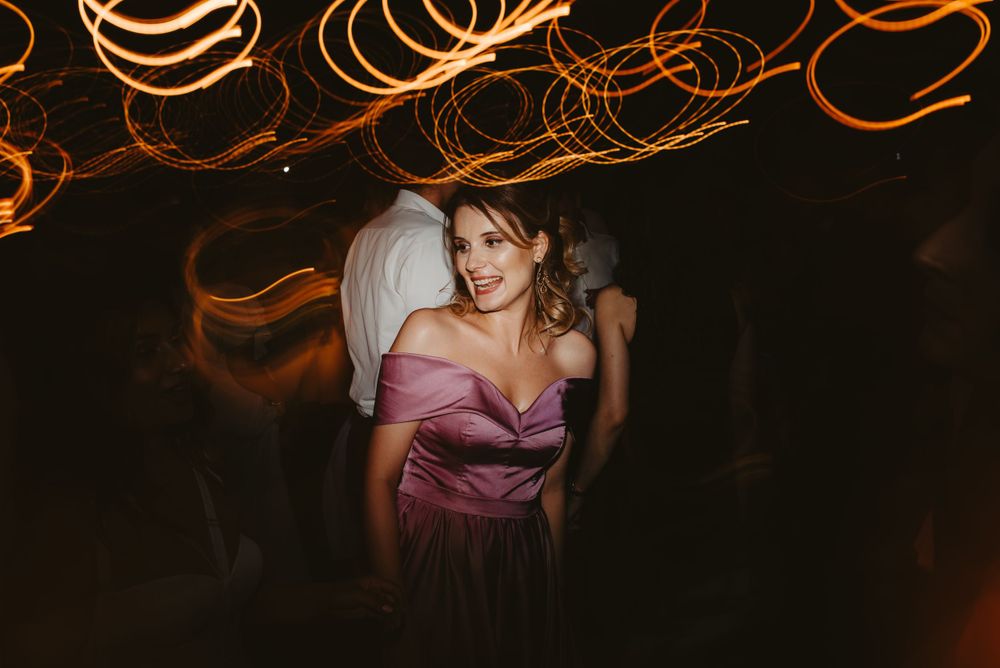 Elegant party scene with swirling orange light trails creating a magical atmosphere.