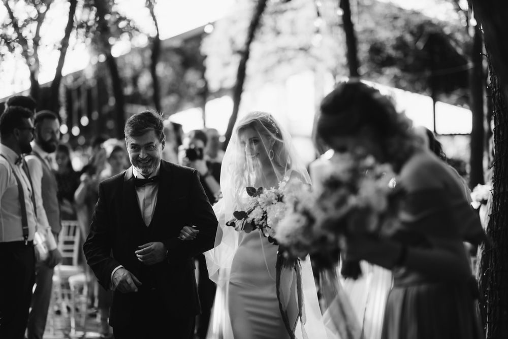 Black and white photo of wedding ceremony attendees gathered outdoors.