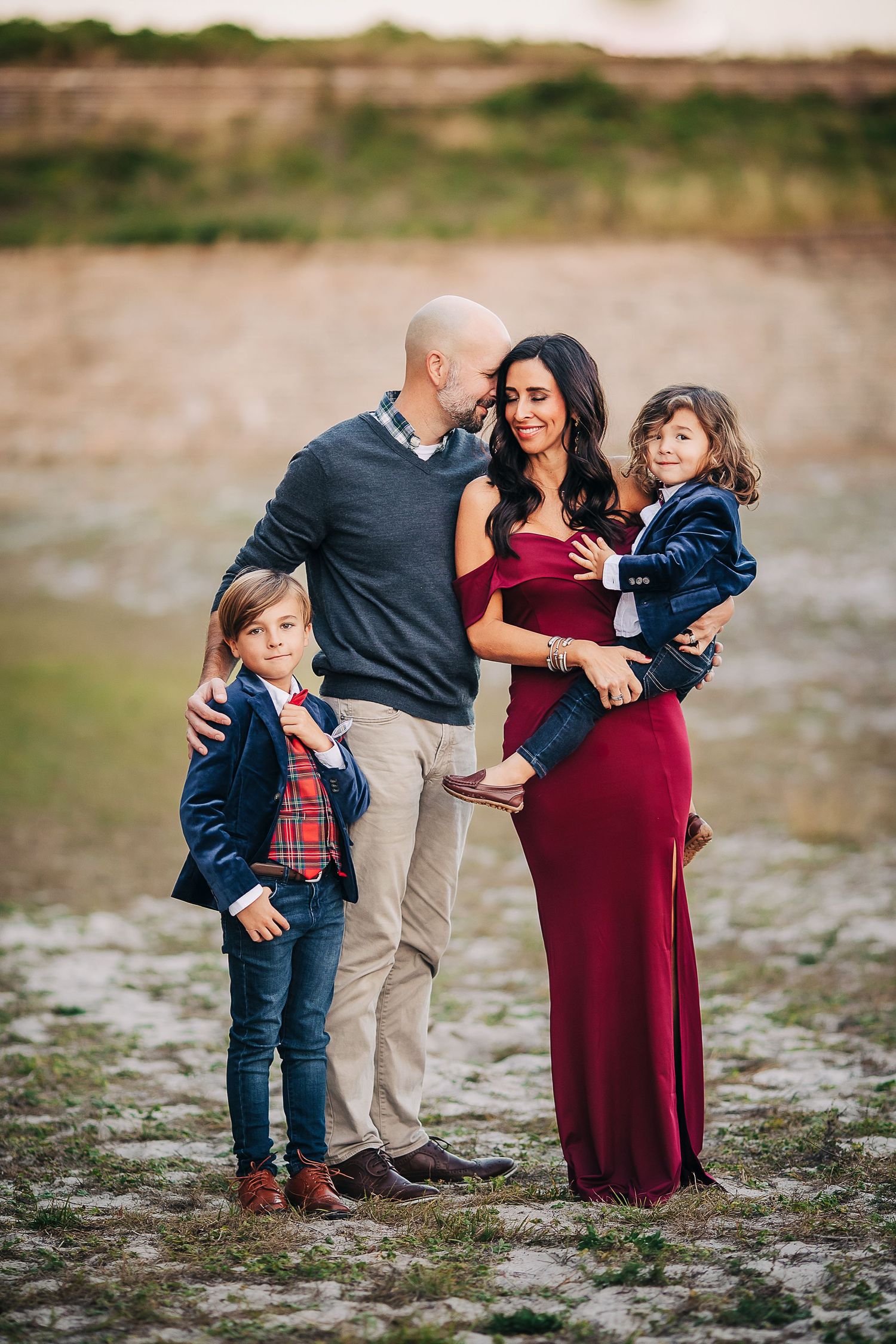 young family cuddling in Navarre Beach  at sunset