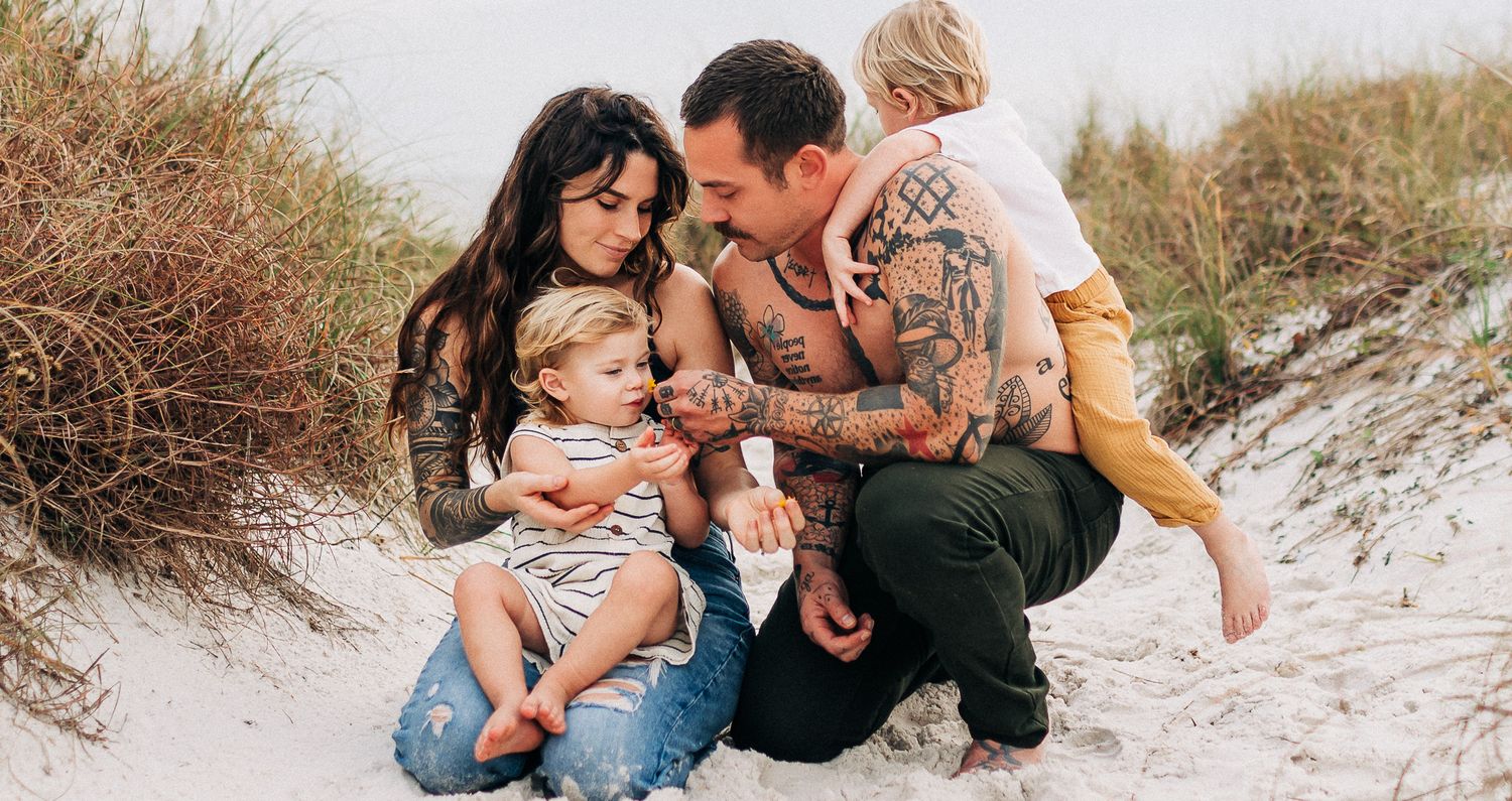 young family cuddling in Navarre Beach  at sunset