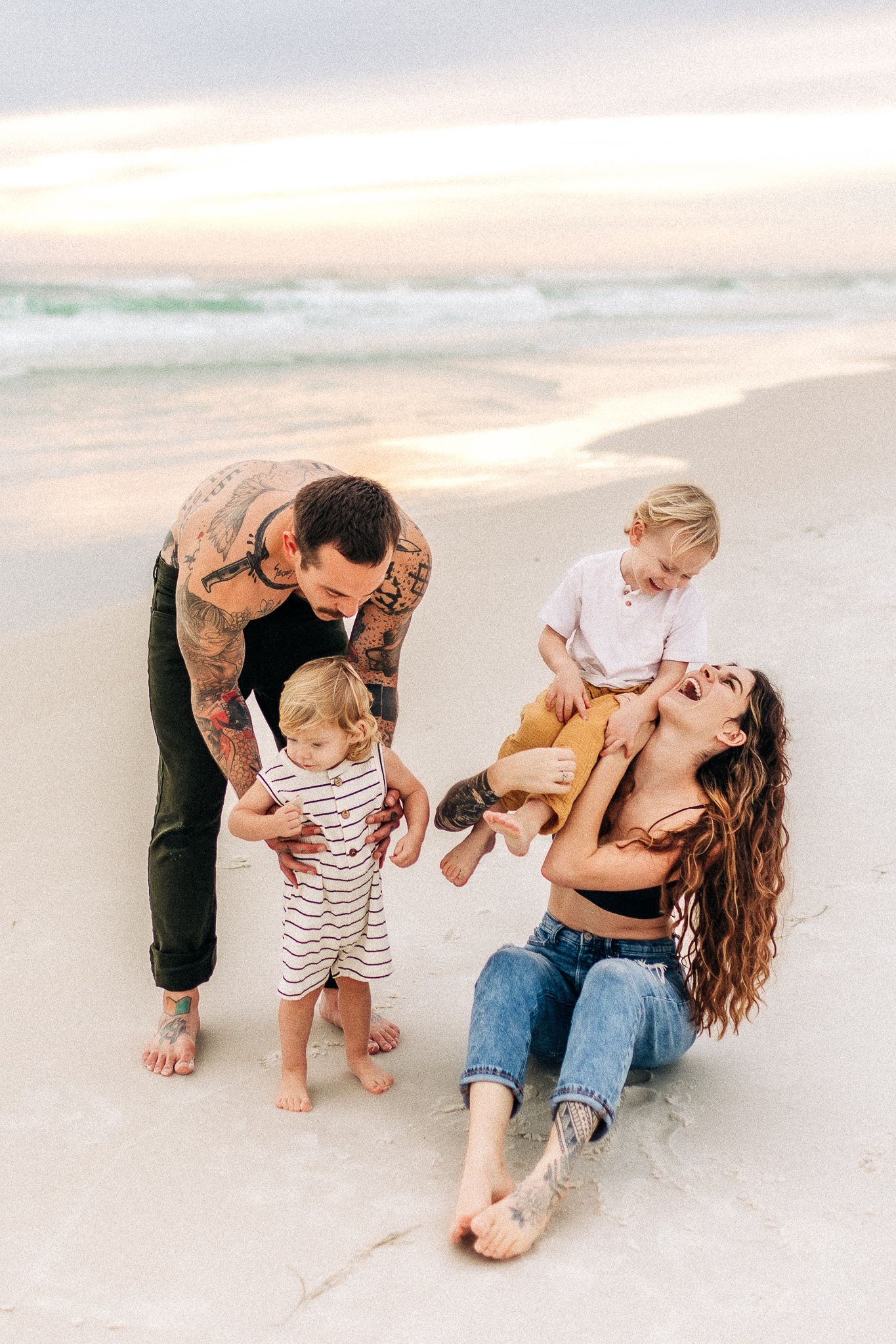 young family cuddling in Navarre Beach  at sunset