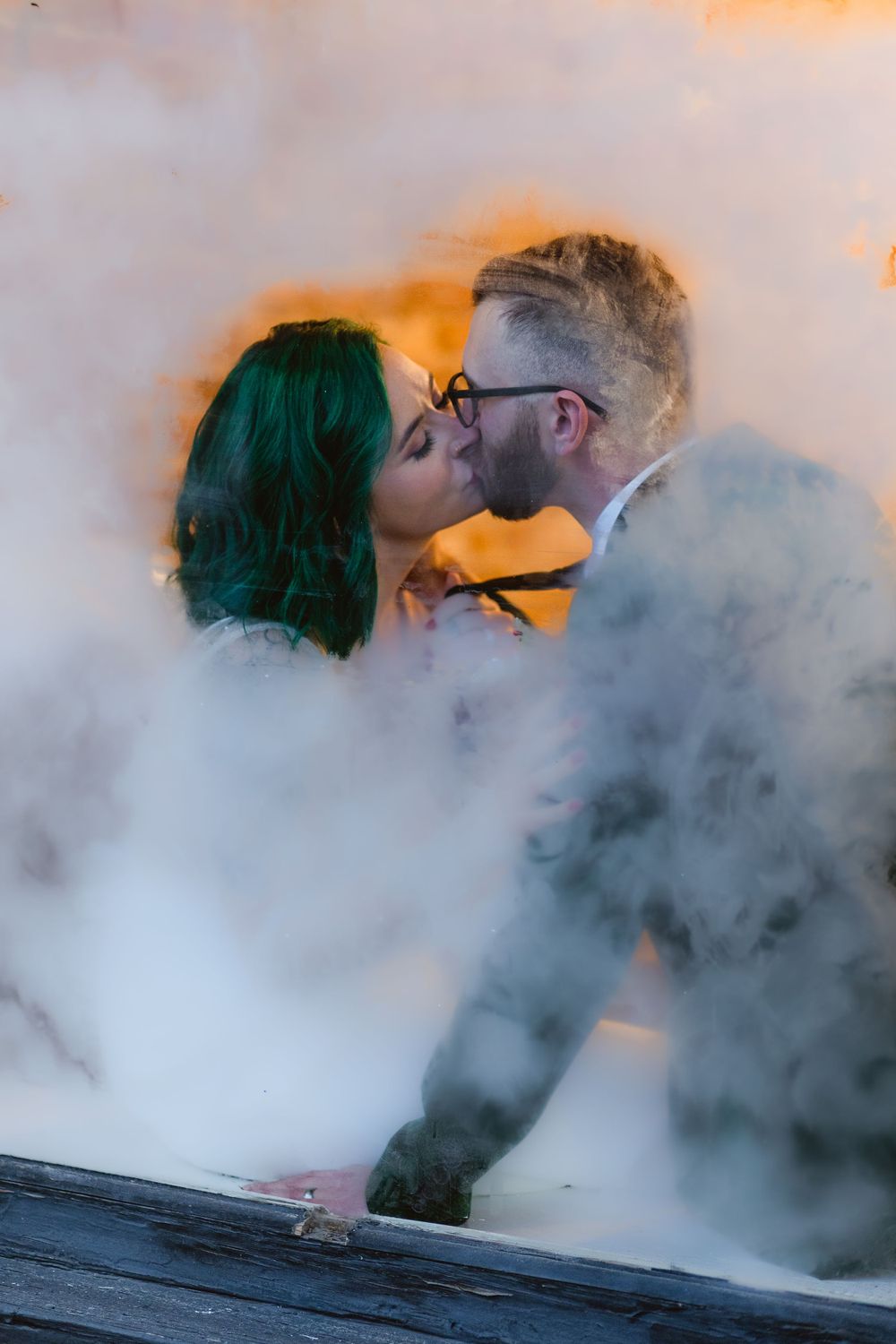 Steamy kiss between groom and bride through a foggy window