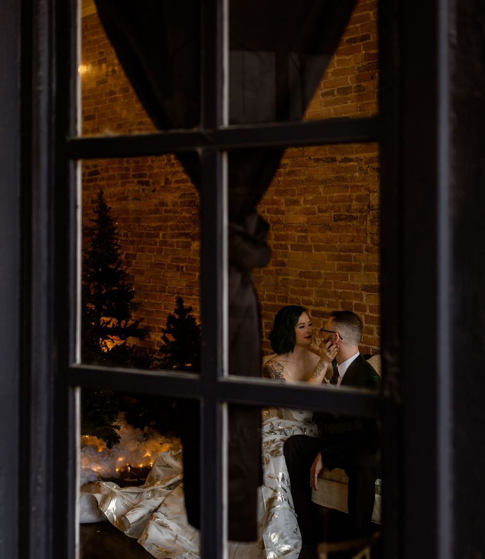 A snapshot in the window of a bride pulling her groom in for a kiss
