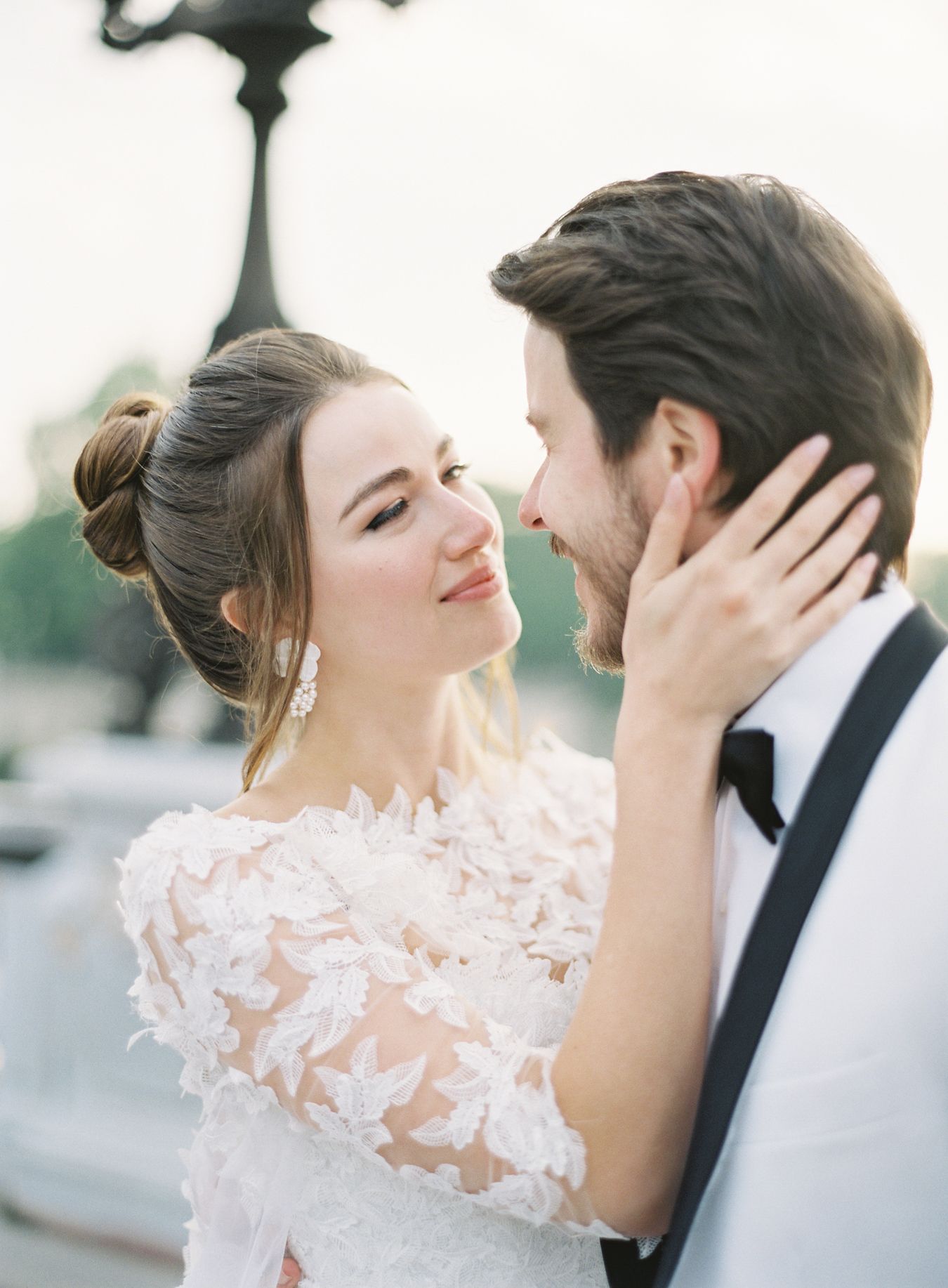 Intimate wedding portrait moment captured against soft white background.