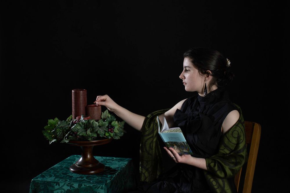Dark moody scene showing candle lighting during a table setting.