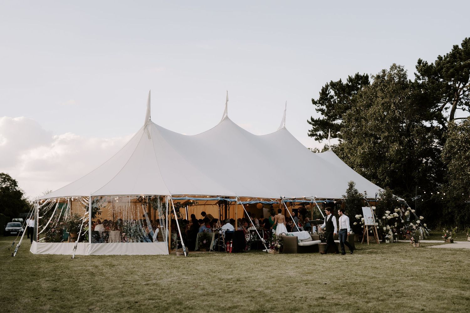 marquee filled with guests on lawn at wedding in islip in Oxfordshire