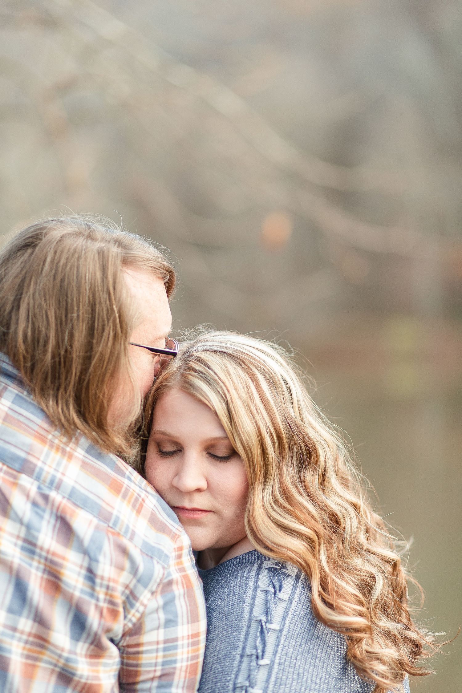 A couple shares an intimate moment during their winter engagement photoshoot.