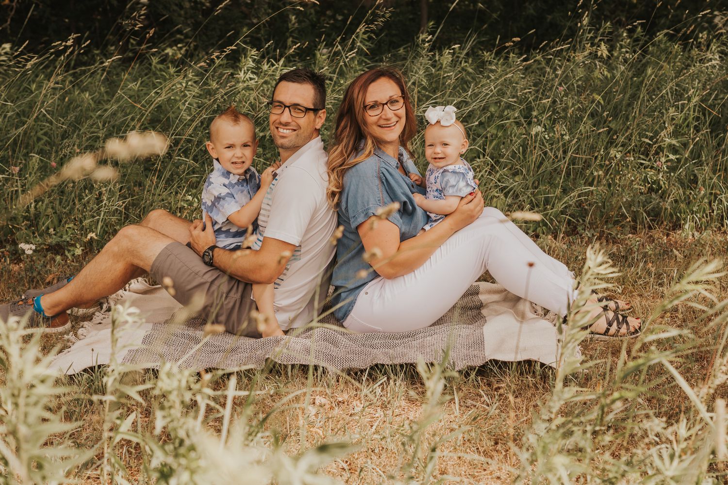 Summer family portrait session in a rustic Michigan setting with tall grass.